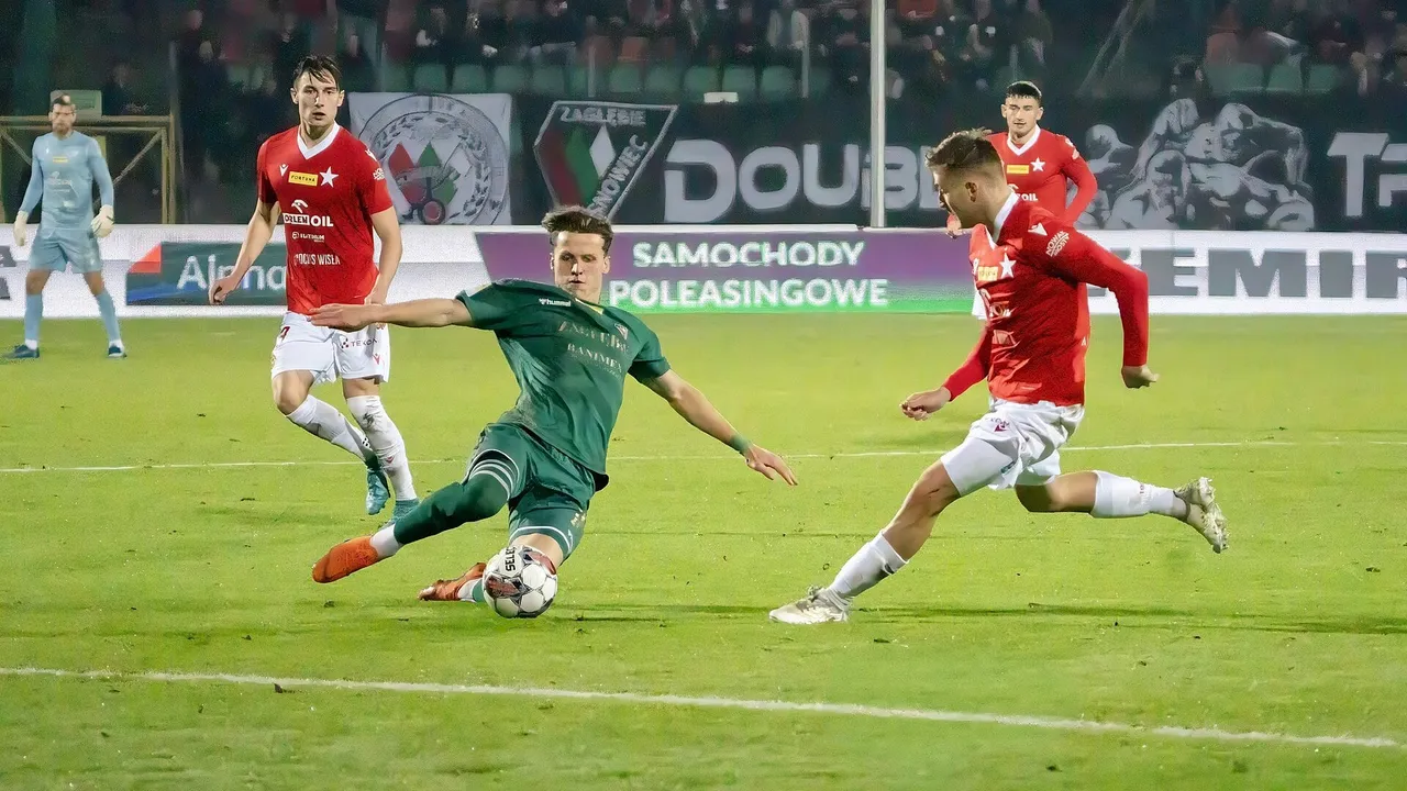 Kırmızı formalı futbolcular yeşil formalı rakibe karşı topu sürüyor